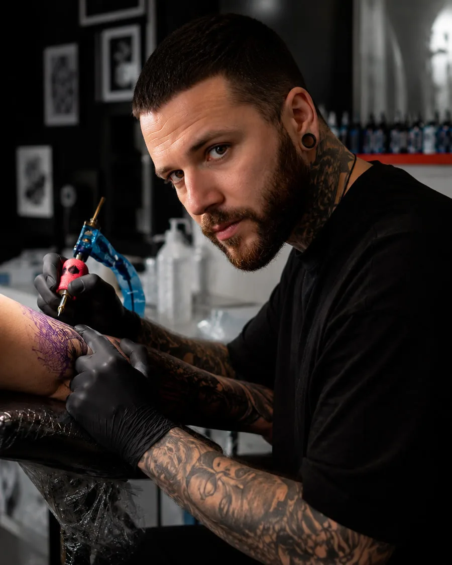 Vincent, tatoueur résident de Tatoo Apex, au travail sur un bras dans le studio